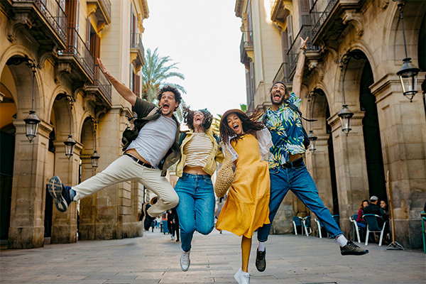 Four young people jumping for joy in a European street
