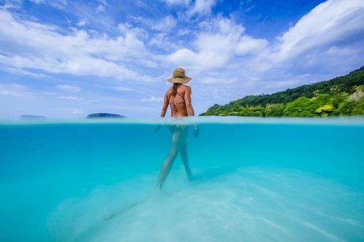 a woman walking through the waters of champagne beach in Espiritu Santo