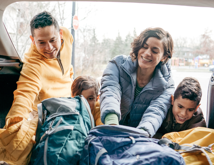 Family packing bags in car