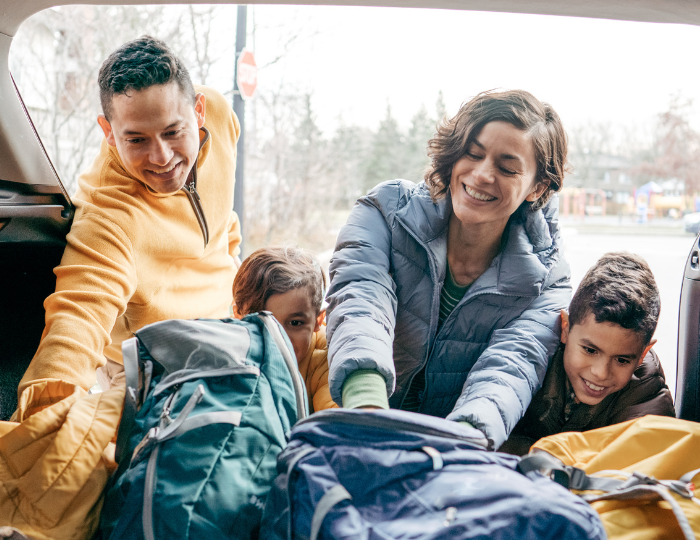 Family packing bags in car 