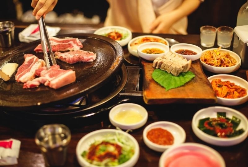 meat on hotplate and condiments that make up Korean Barbecue