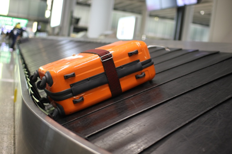 Orange suitcase on conveyer belt 