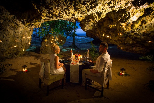 couple having romantic dinner in seaside cave in fiji