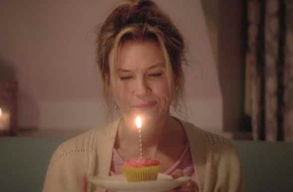  Woman holding a cupcake with a candle light 