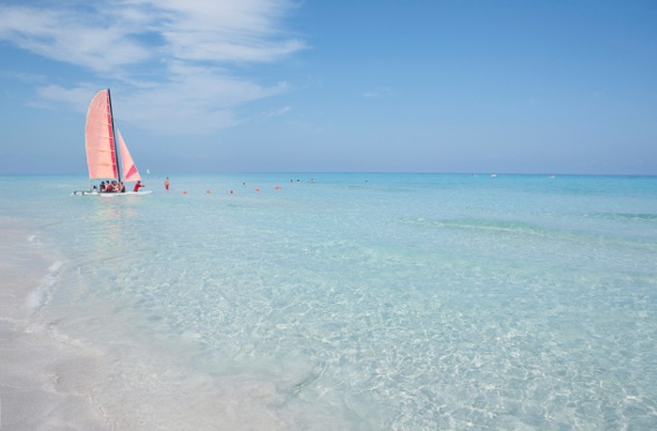  a boat with red sail wandering in the midst of Cuba Varadero
