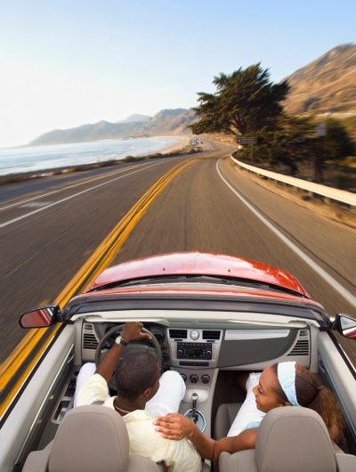 Top shot of a couple driving around using a red convertible car