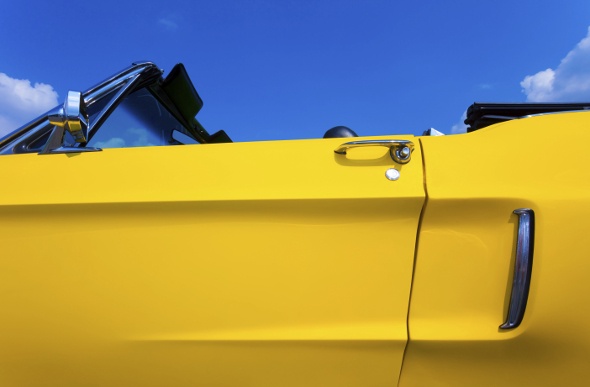 Close-up shot of the door of a yellow convertible Ford Mustang 