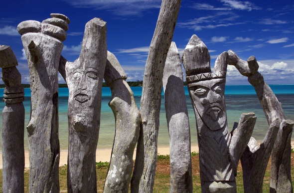 Tiki masks carved onto the wooden fences that line the beach