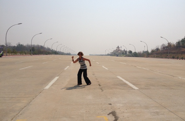  a short-haired woman dancing in the middle of the airport's highway