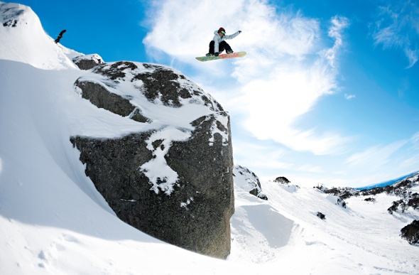  Person snowboarding over a huge rock