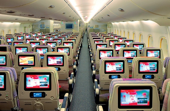 Airplane seats with screen displays attached at the back of each one