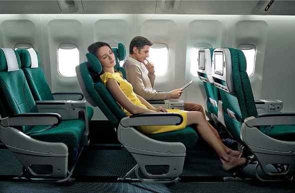  Lady relaxes with her seat reclined while a man reads next to her in flight