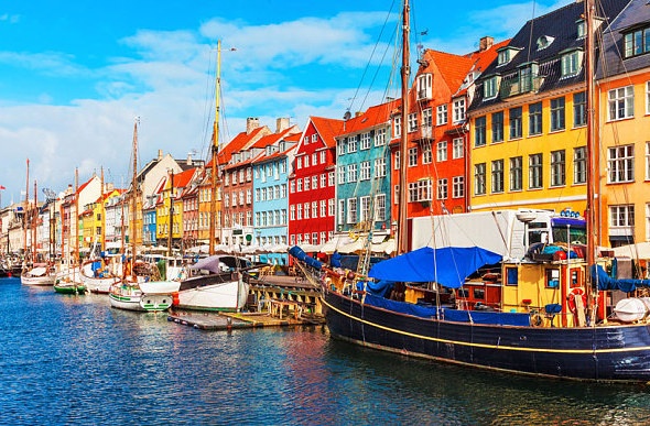 Colorful houses at the Nyhavn Harbor with few boats dock in front