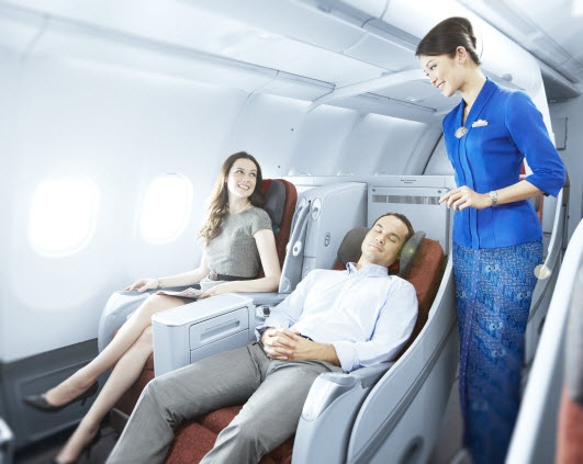The flight attendant of Garuda Indonesia entertaining a couple in the plane