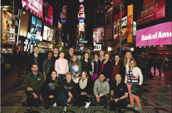  Group of tourists posing for a photo in New York City's Time Square