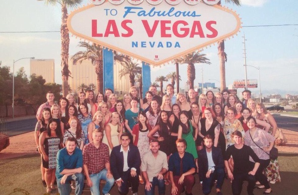 Group of tourists poses for a photo in front of the Las Vegas welcome sign