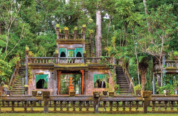 The ruins of Paronella Castle surrounded by dense tropical rainforest. Paronella Park is in Tropical North Queensland