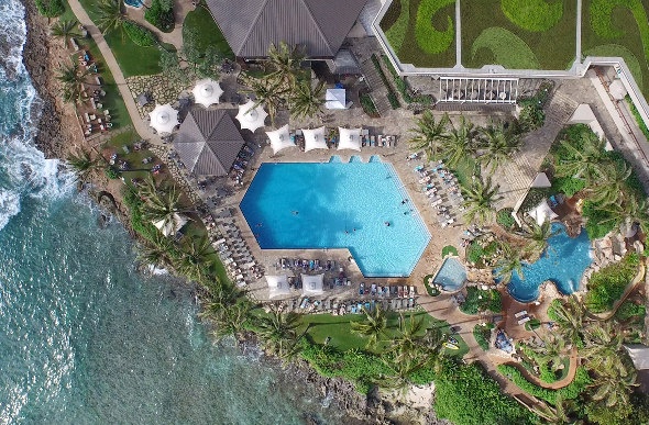 An aerial shot of the ground of Turtle Bay Resort on the North Shore of Oahu shows the pool areas and the ocean