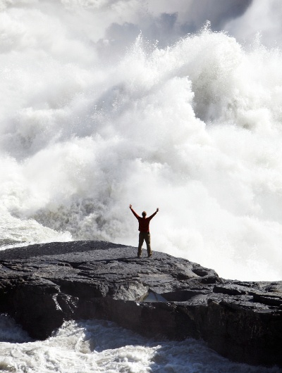 A man stands in front of Virginia Falls in Canada's Northwest Territories