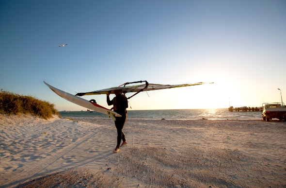 A windsurfer walks along the beach at Lancelin in Western Australia.