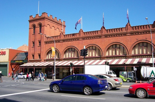  blue, silver, and red cars passing by the Adelaide central market