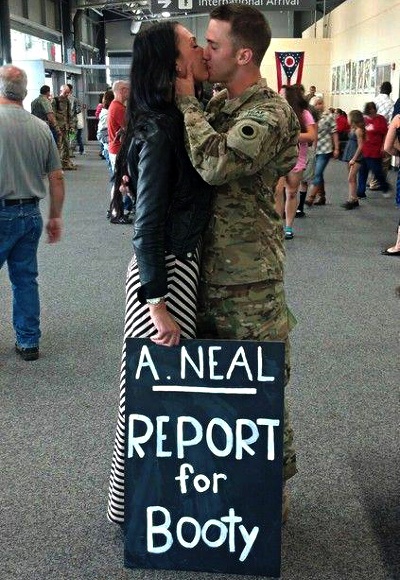 Couple kissing holding sign 