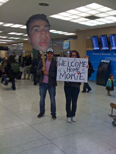  people holding signs in the airport 
