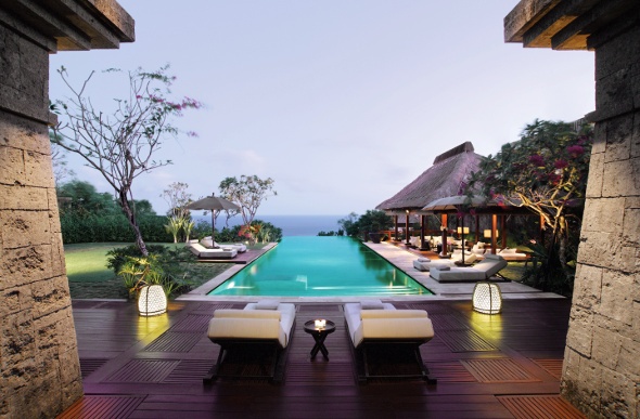 Sunlounges on a wooden pool deck at a tropical resort