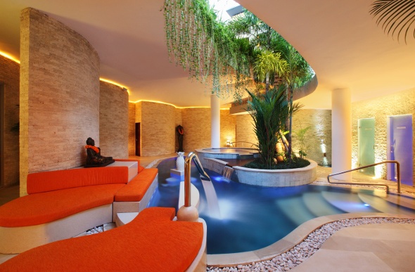 Well-lit indoor pool with seating area
