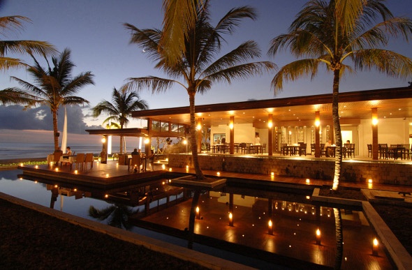 Cozy resort at night with pool and palm trees 