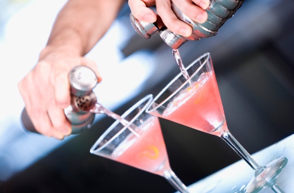  Bartender pouring cocktails in two glasses