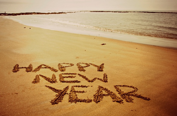  the phrase happy new year written on the sand of the beach