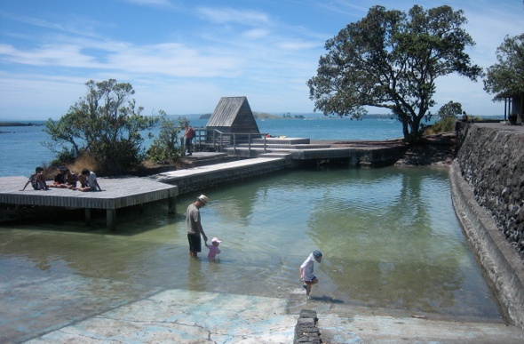  a father with his children taking a dip in Rangitoto beach