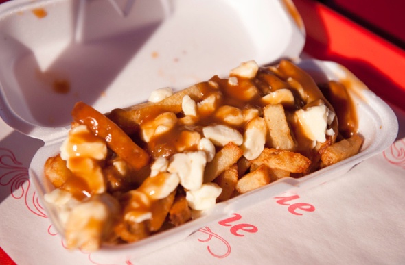 Loaded fries with poutine and gravy in a takeaway container