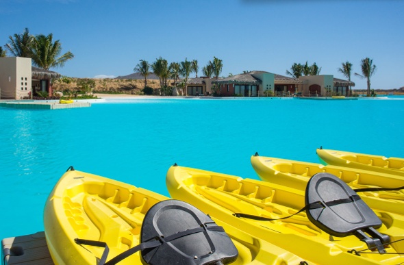  thre yellow kayak boats line up on the teal waters of the diamante crystal lagoons