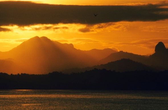 Light beams as the sun sets in the mountains of Suva in Fiji