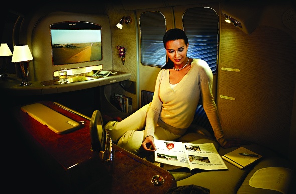  Woman sitting comfortably in a luxurious plane seat reading a magazine