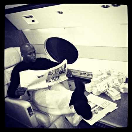  Floyd Mayweather with his feet up reading the paper on a plane 