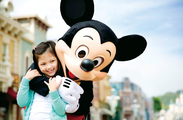 Mickey mouse hugging a young tourist