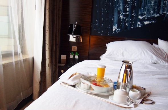  Tray with breakfast and drinks on a hotel bed 
