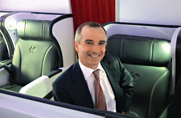  john borgetti smiling on the camera while sitting on the green couch in business class