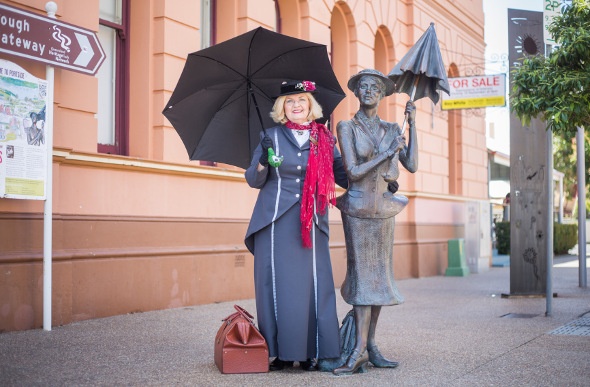 A woman dresses up as Mary Poppins to visit the statue of her creator in Maryborough, Queensland.