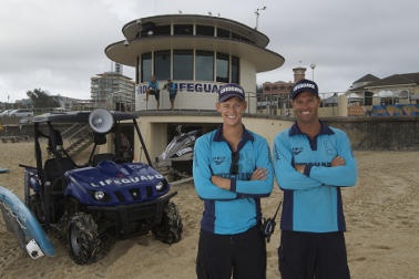 Two Bondi lifeguards in front of their tower 
