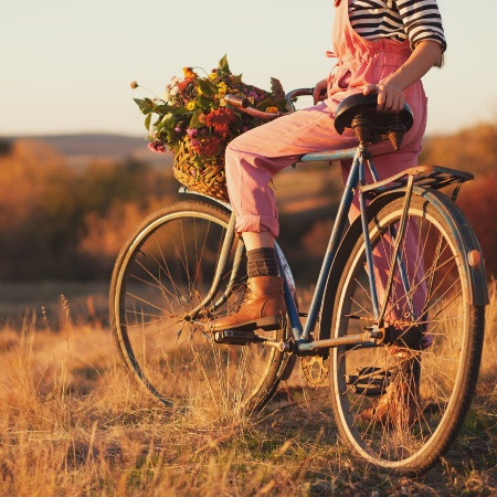  lady in a bike with basket of flowers