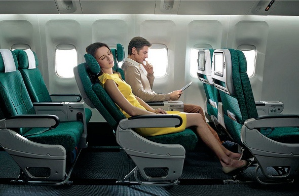 Lady relaxes with her seat reclined while a man reads next to her in flight