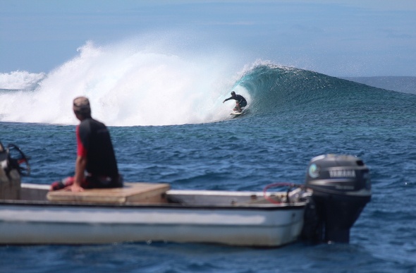 A surfer riding a wave in Samoa
