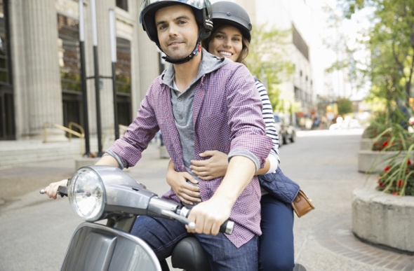  Man and woman riding on a scooter together 
