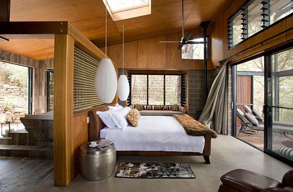  a wooden themed room with a white king sized bed and white cocoon-like hanging lamps