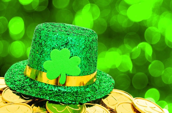  a gree glittery hat with a golden ribbon and four leaf clover in the middle sitting on a pot of golden four leaf clover coins