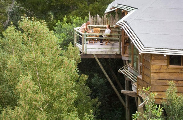 Couple relaxes and enjoys the scenery from the balcony of a cabin house
